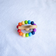 Newborn teether and Montessori toys. Handmade bird shaped teether made with BPA-free silicone and beech wood timber teething ring. Made in Australia by Bowerbird Creations. Tweet teether in bright rainbow.