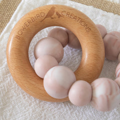 Teething Toy handmade from silicone and beech wood. Made in Australia by Bowerbird Creations. Pink Marble Halo Teether Toy on white background.