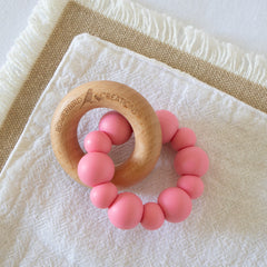 Handmade teething toy for babies, made from non-toxic silicone and beech wood. Pink. Made in Australia by Bowerbird Creations.