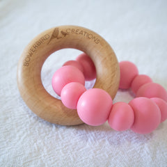 Handmade teething toy for babies, made from non-toxic silicone and beech wood. Pink. Made in Australia by Bowerbird Creations.