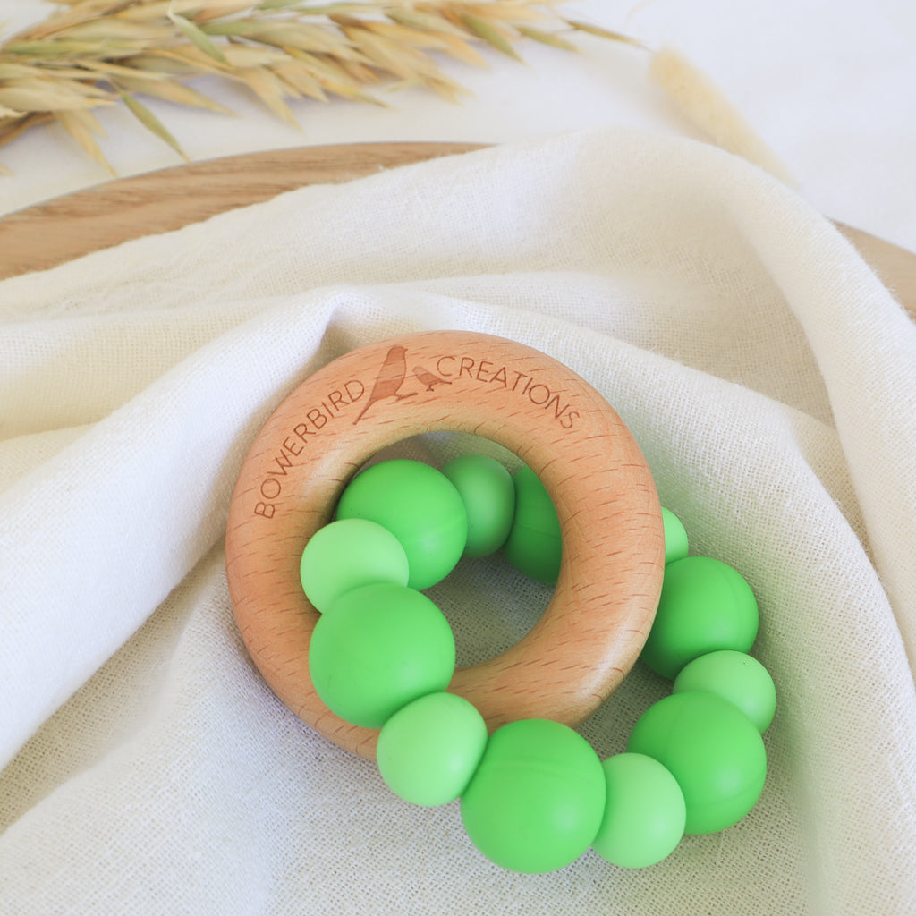Handmade teething toy for babies, made from non-toxic silicone and beech wood. Green. Made in Australia by Bowerbird Creations.