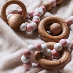 Close up of 3 pink baby play gym toy made from silicone and wood