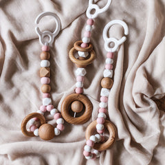 Close up of 3 pink baby play gym toy made from silicone and wood