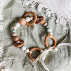 Handmade silicone and wood pram toy in sage, beige and printed leafy beads