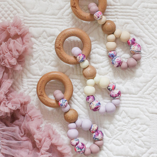 Teething toys handmade from silicone and beech wood. Made in Australia by Bowerbird Creations. Infinity teether toy in purple, mauve, lilac, beige and roses.