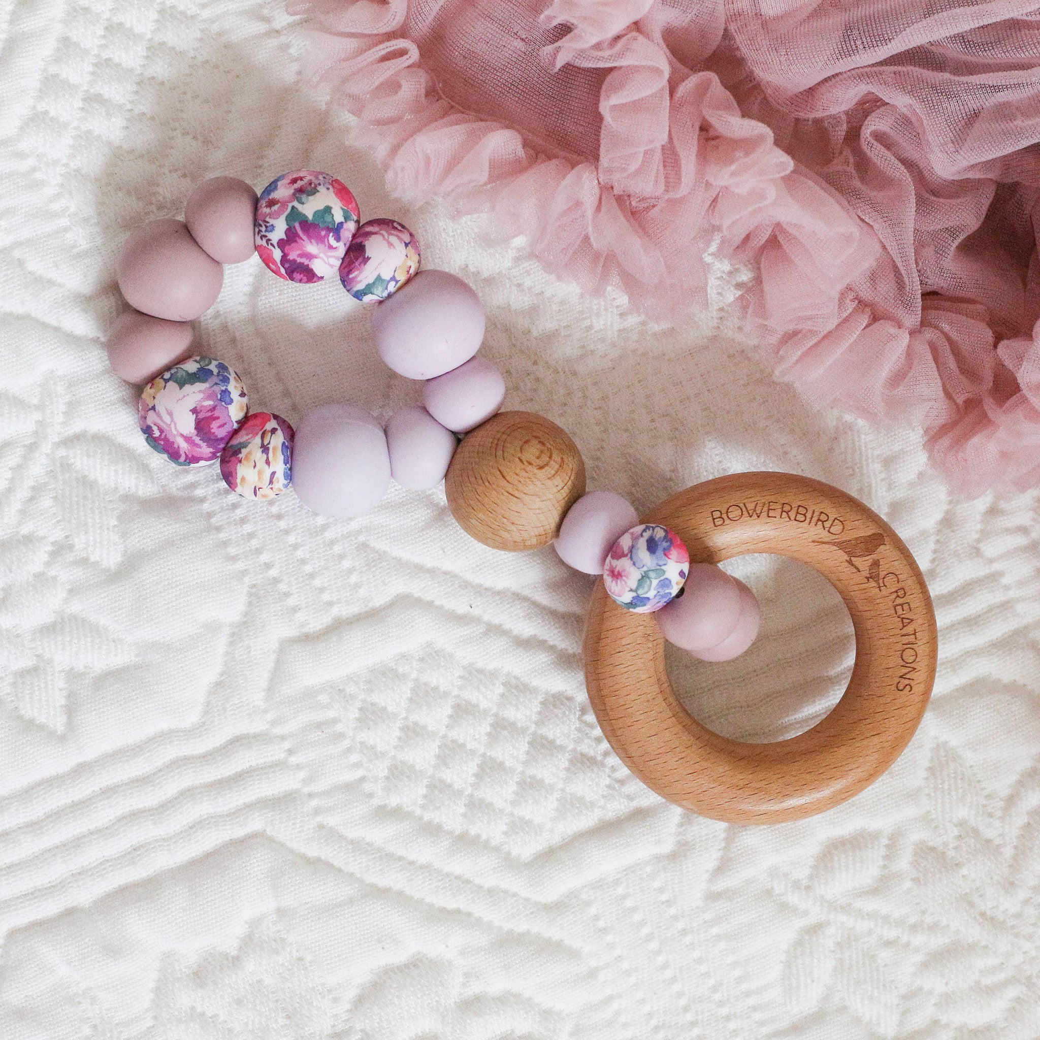 Teething toys handmade from silicone and beech wood. Made in Australia by Bowerbird Creations. Infinity teether toy in purple, mauve, lilac and roses.