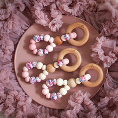Teething toys handmade from silicone and beech wood by Bowerbird Creations. Made in Australia. Pink, beige, cream and roses.