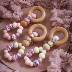 Teething toys handmade from silicone and beech wood by Bowerbird Creations. Made in Australia. Pink, beige, cream and roses.