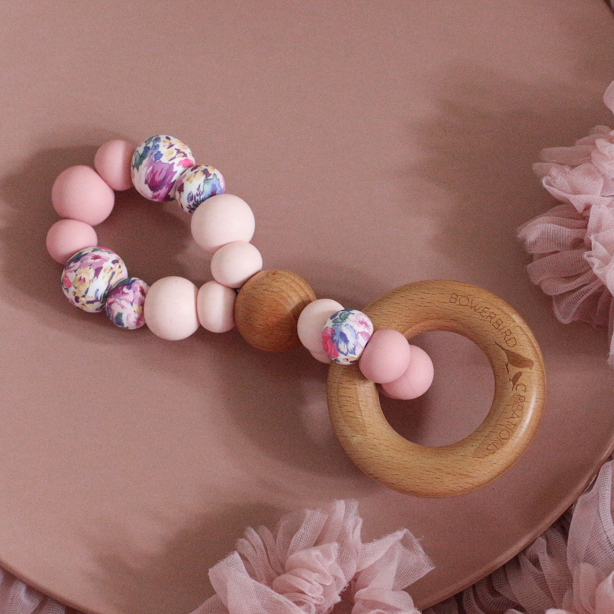 Teething toys handmade from silicone and beech wood by Bowerbird Creations. Made in Australia. Pink and roses.