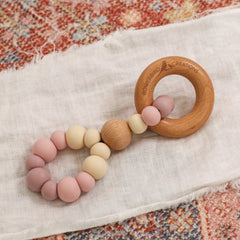 Teething toy handmade in Australia by Bowerbird Creations. Silicone and Beech wood. Neutral pink, mauve and beige.