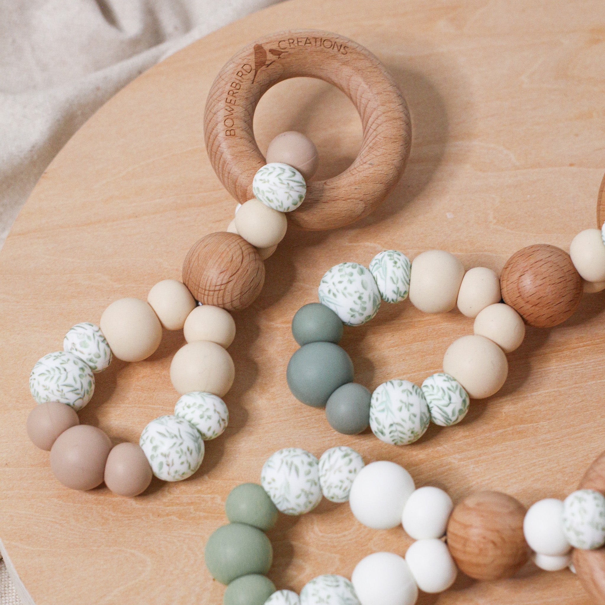 Teething toys infinity. Handmade from silicone and beech wood by Bowerbird Creations. Made in Australia. Beige, Sage, Eucalyptus. Close up photo.
