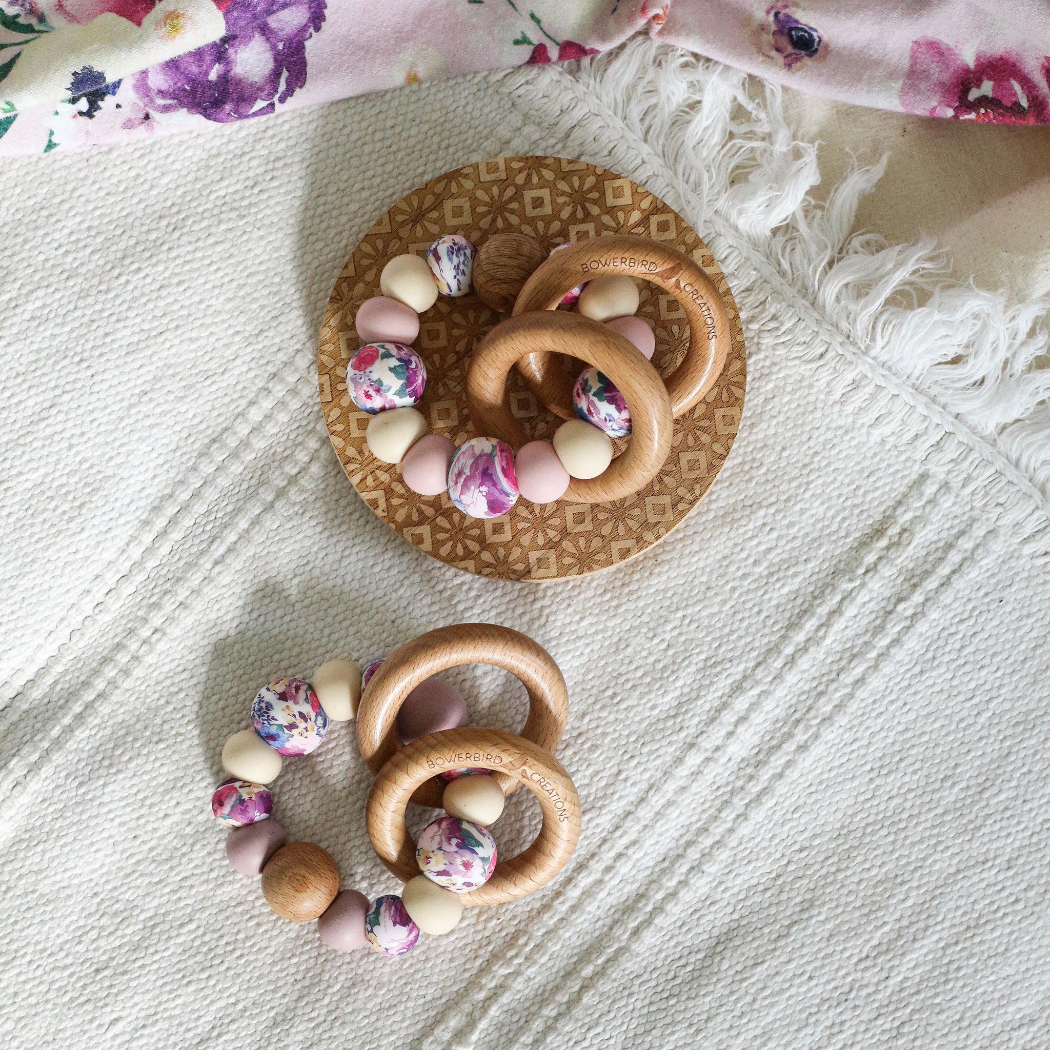 Teething and Montessori toys. Handmade newborn teether with wood teething rings that rattle when shaken. Handmade in Australia from BPA-free silicone and beech wood timber. Dreamer teether by Bowerbird Creations. Pink, purple, mauve, beige and floral.