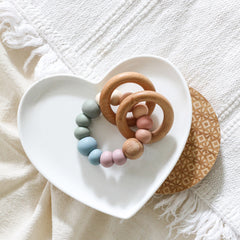 Newborn teether and montessori toys. Handmade with BPA-free silicone and natural beech wood timber teething rings. Dreamer teething toy by Bowerbird Creations. Made in Australia. Muted rainbow.