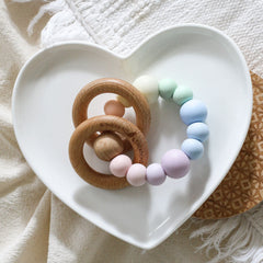 Newborn teether and montessori toys. Handmade with BPA-free silicone and natural beech wood timber teething rings. Dreamer teething toy by Bowerbird Creations. Made in Australia. Pastel rainbow.