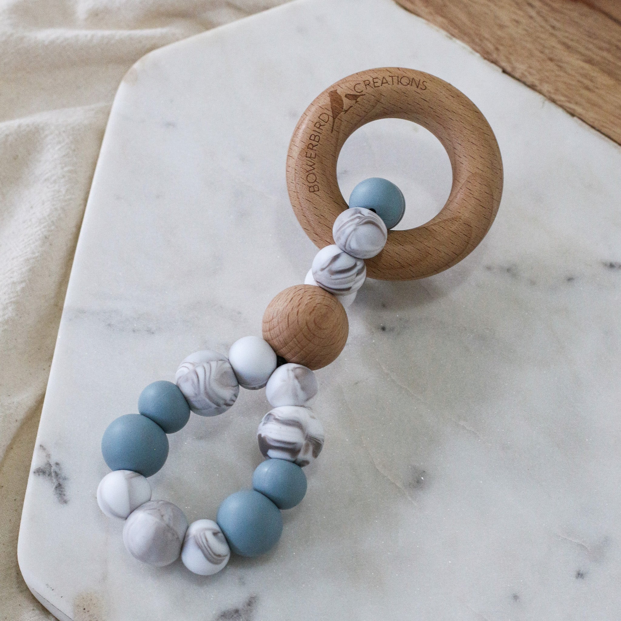 Infinity teething toy in marble and blue. Handmade from silicone and beech wood timber teething ring. Made in Australia by Bowerbird Creations.