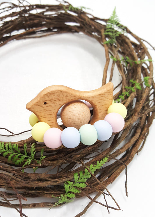 Bird shaped teething/sensory toy for babies. Pastel rainbow, handmade from silicone and natural beech wood.