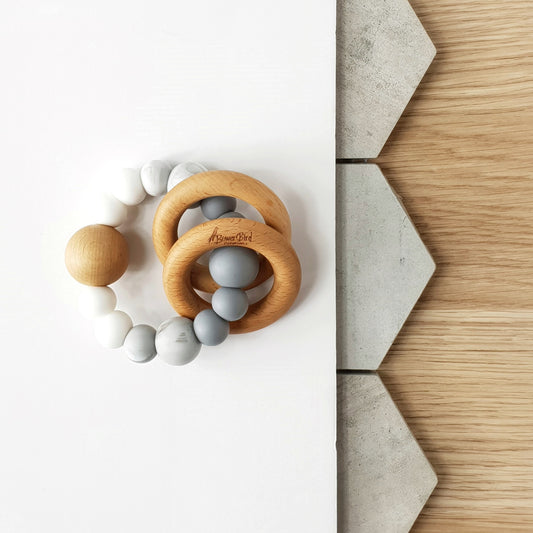 Newborn teether and montessori toys. Handmade from silicone and beech wood timber teething rings that rattle when shaken. Made in Australia. Non-toxic and safe. Grey, marble and white. 