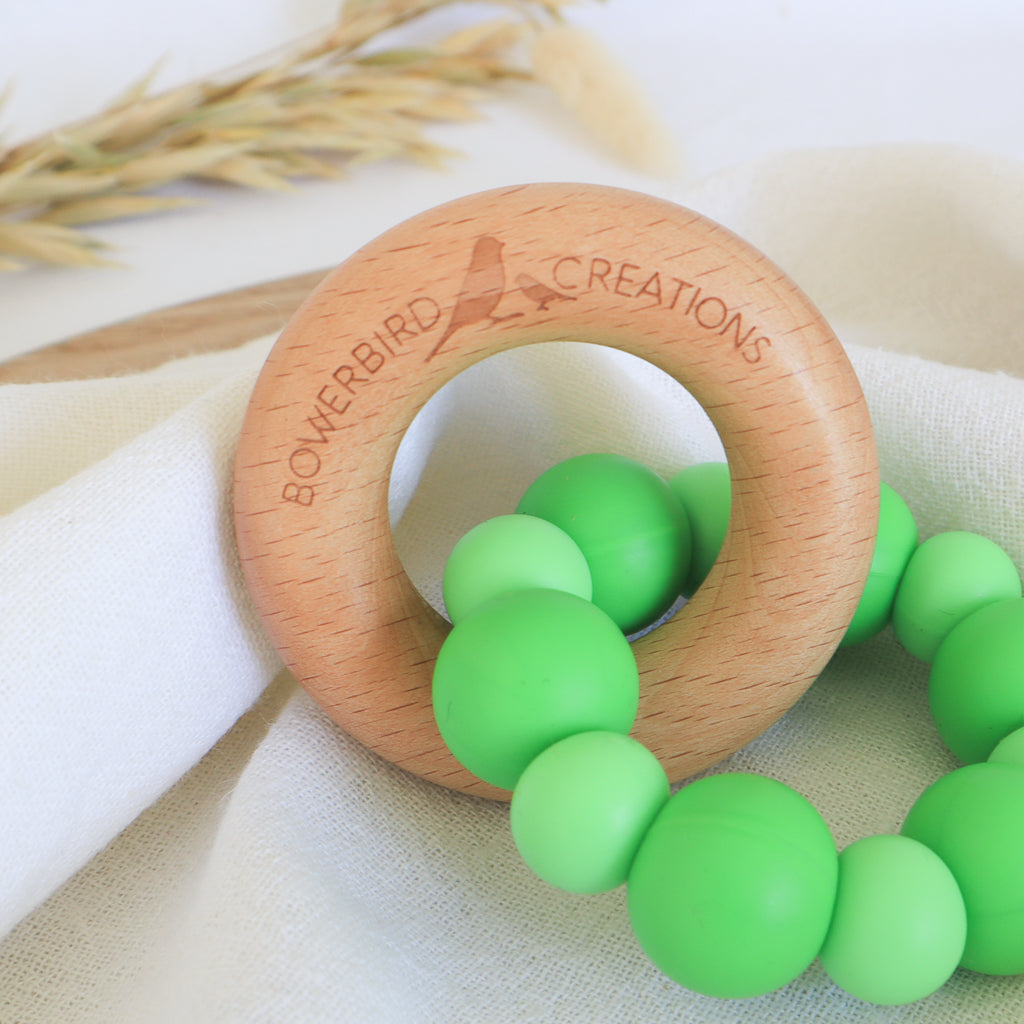 Handmade teething toy for babies, made from non-toxic silicone and beech wood. Green. Made in Australia by Bowerbird Creations. 