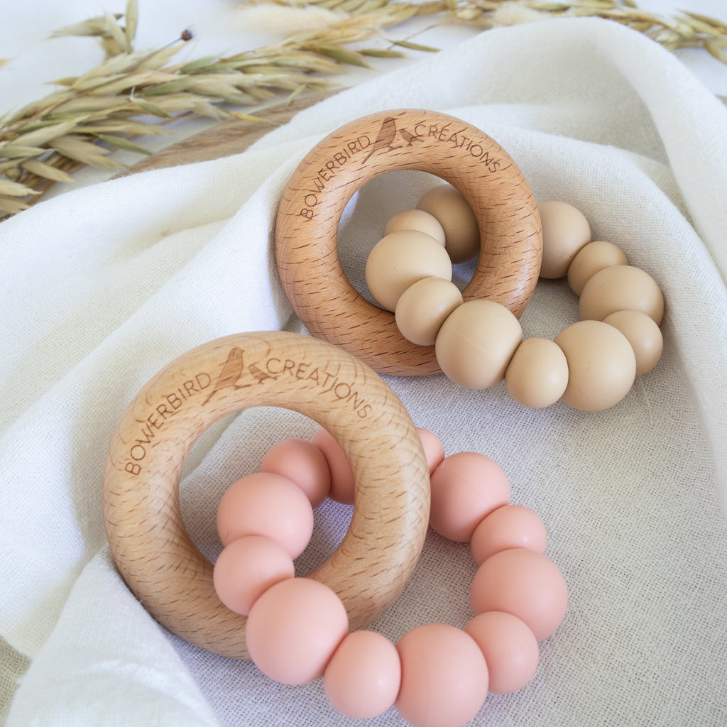 Handmade teething toy for babies, made from non-toxic silicone and beech wood. Peach and beige. Made in Australia by Bowerbird Creations. 
