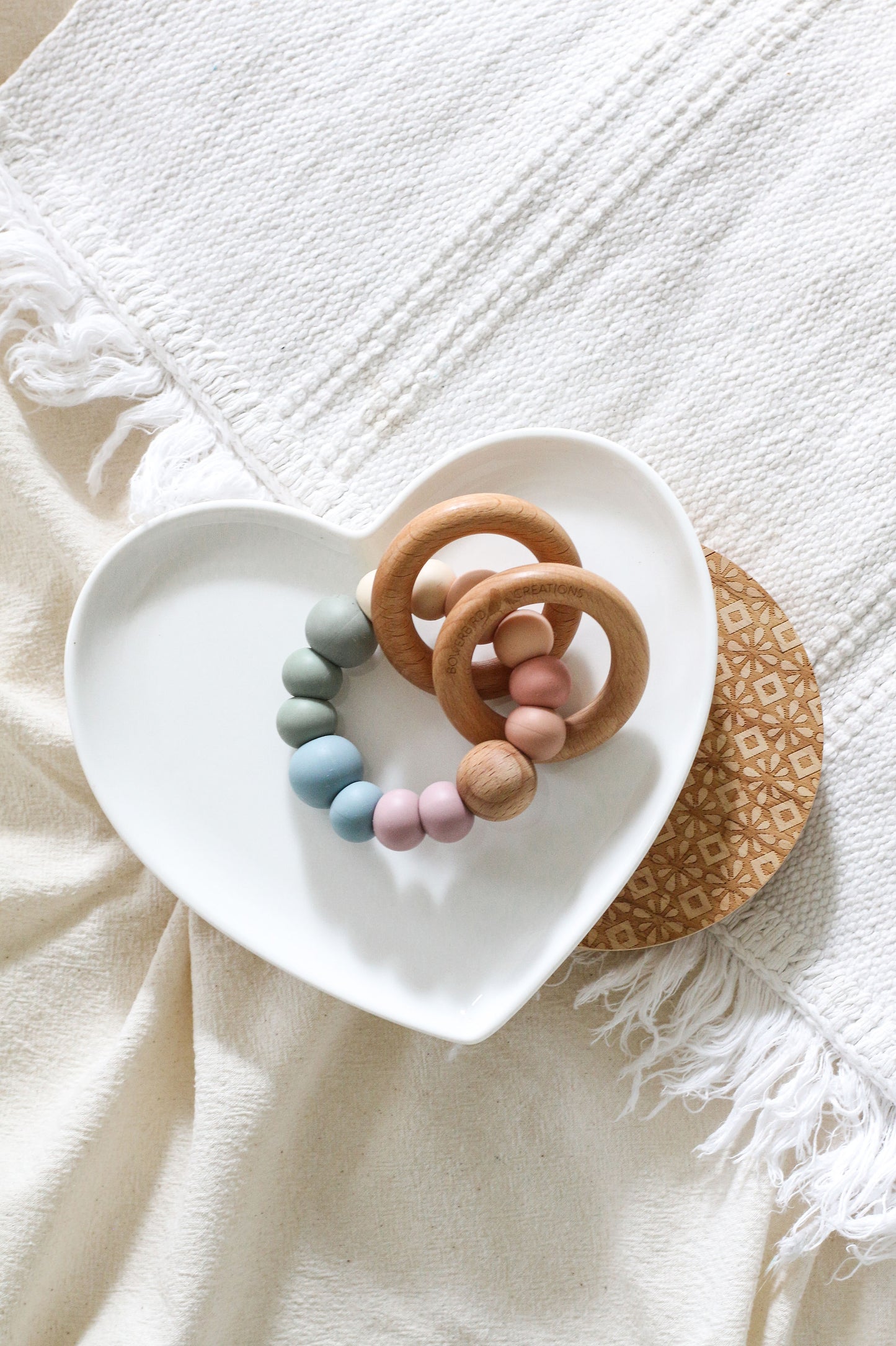 Teether/sensory toy featuring 2 wooden rings that rattle. Handmade from silicone and natural wood. Pastel and muted rainbow. Muted rainbow.