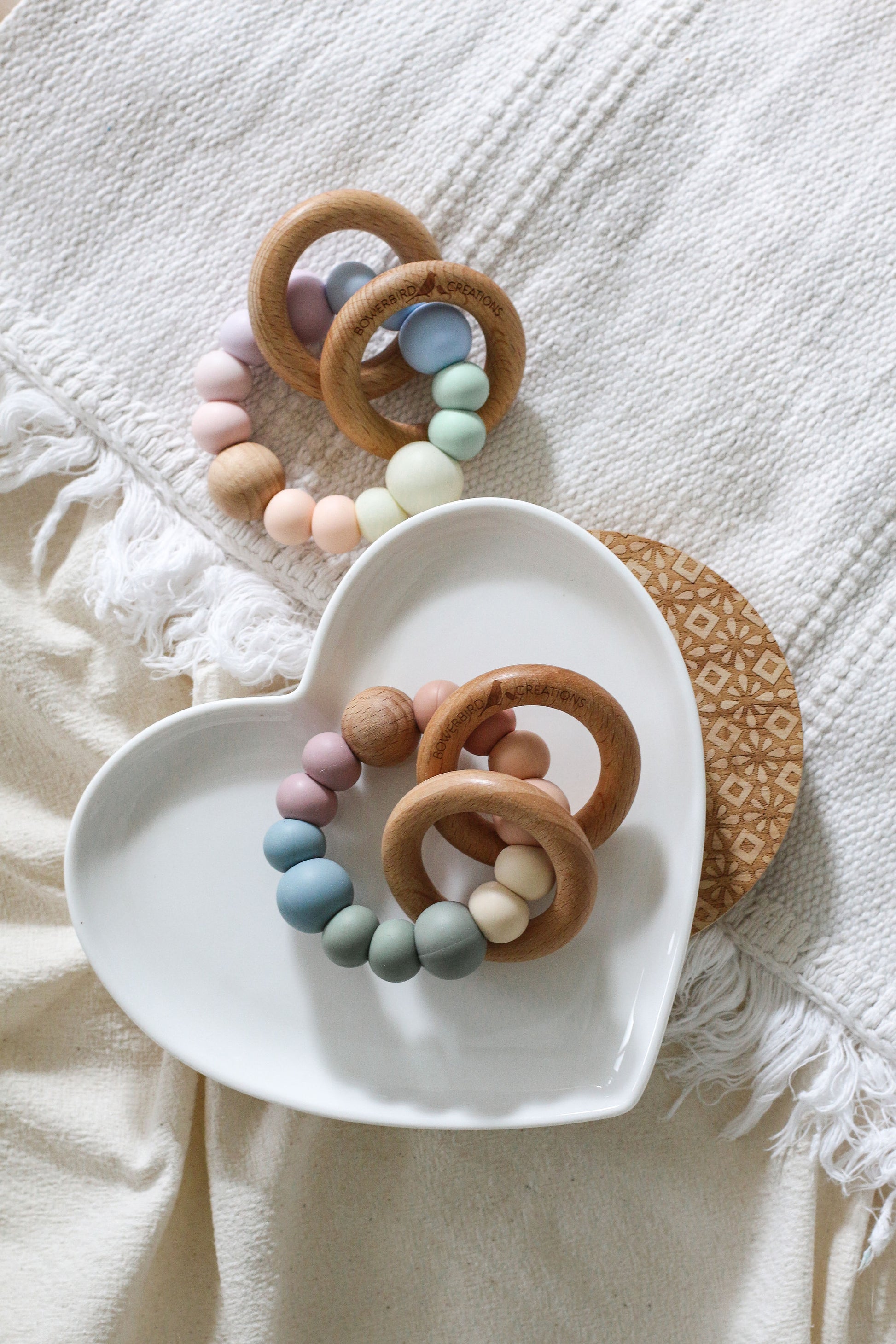 Teether/sensory toys featuring 2 wooden rings that rattle. Handmade from silicone and natural wood. Pastel and muted rainbow.