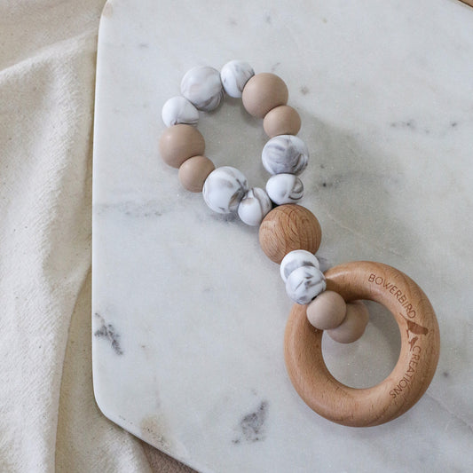 Handmade teething toy in beige and marble. Made in Australia by Bowerbird Creations from BPA-free silicone and beech wood. 