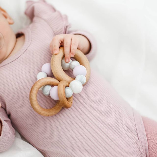 Silicone teething toy for baby with 3 wooden rings. Pink, white, marble.