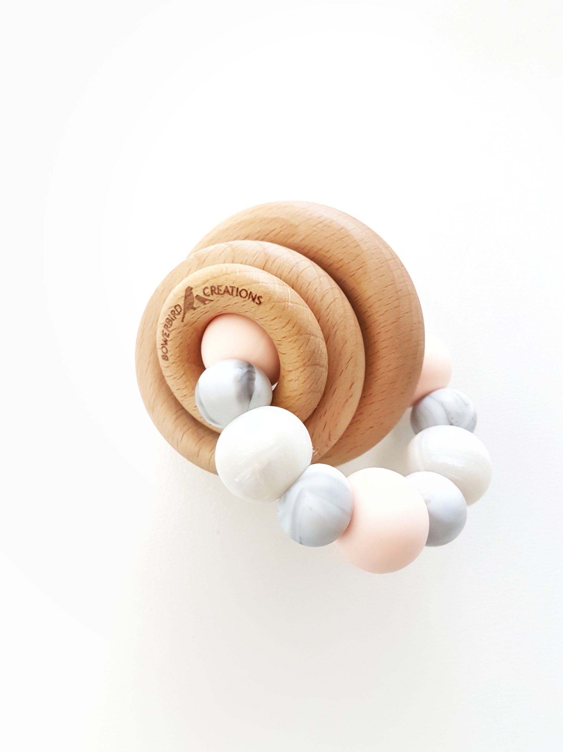 Silicone teething toy for baby with 3 wooden rings. Pink, white, marble.