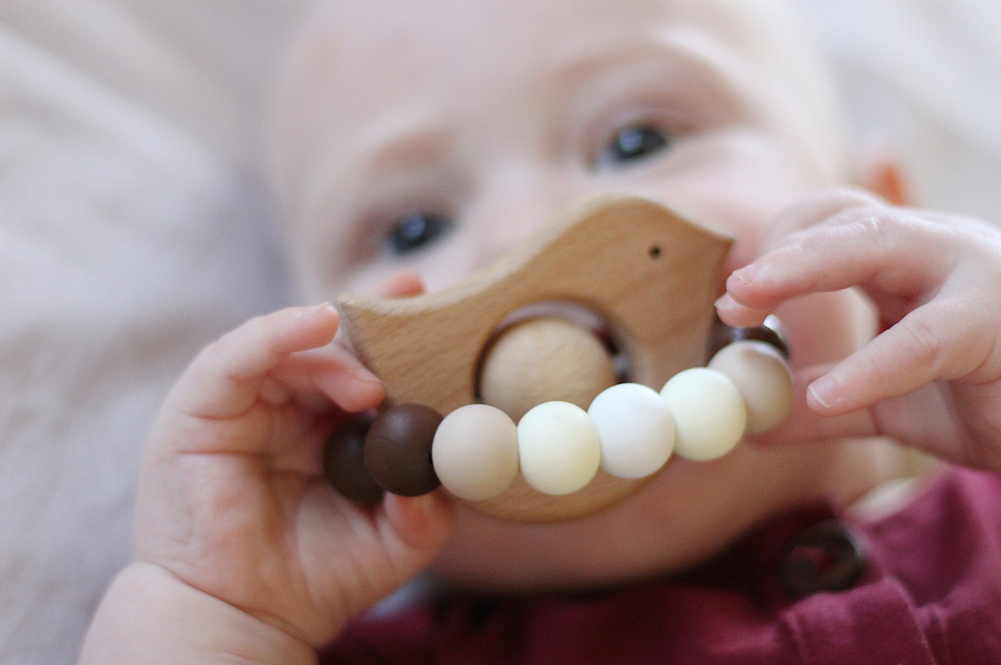 Baby chewing bird shaped teething/sensory toy for babies. Neutral/beige, handmade from silicone and natural beech wood.